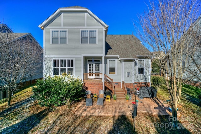 view of front of home featuring roof with shingles and a patio area