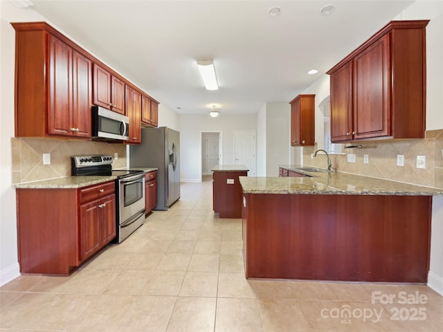 kitchen featuring light tile patterned floors, sink, kitchen peninsula, stainless steel appliances, and light stone counters