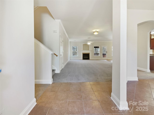 foyer entrance featuring crown molding, light colored carpet, and ceiling fan