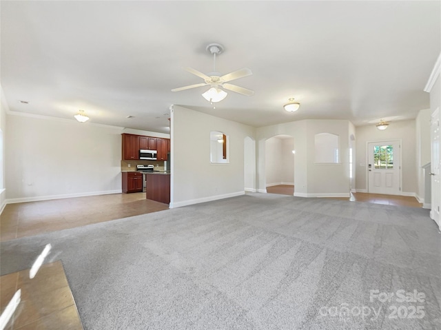 unfurnished living room featuring crown molding, carpet flooring, and ceiling fan