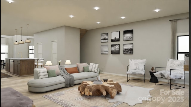 living room featuring sink, a healthy amount of sunlight, and light hardwood / wood-style floors