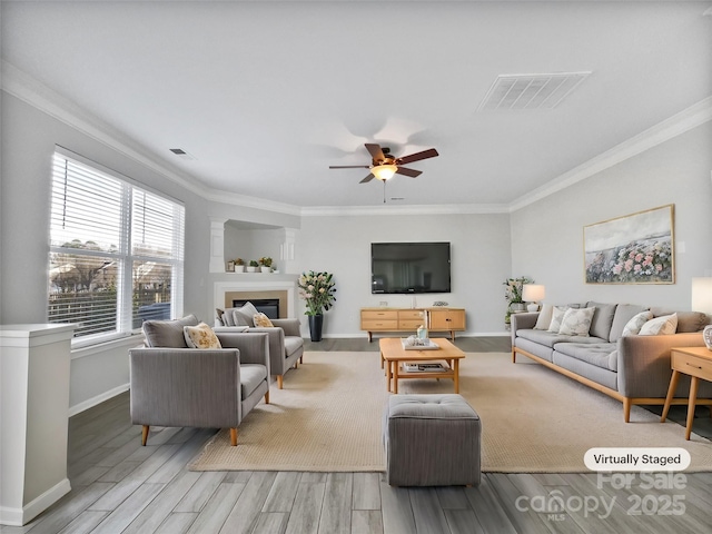 living room featuring light hardwood / wood-style floors, ceiling fan, and ornamental molding