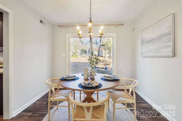 dining room with dark hardwood / wood-style floors and an inviting chandelier