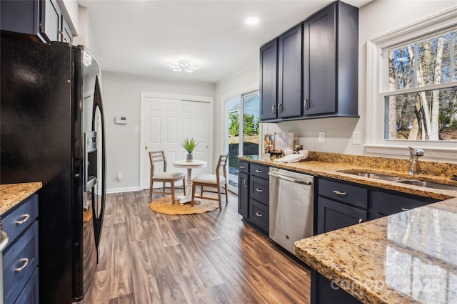 kitchen featuring dark hardwood / wood-style floors, sink, stainless steel dishwasher, black fridge with ice dispenser, and light stone countertops