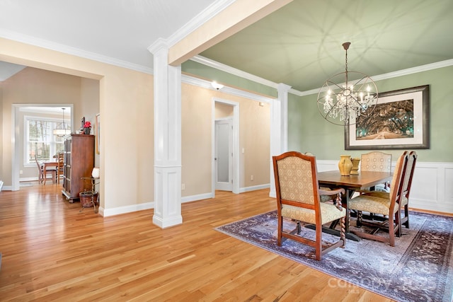 dining area with ornate columns, ornamental molding, wood-type flooring, and a chandelier