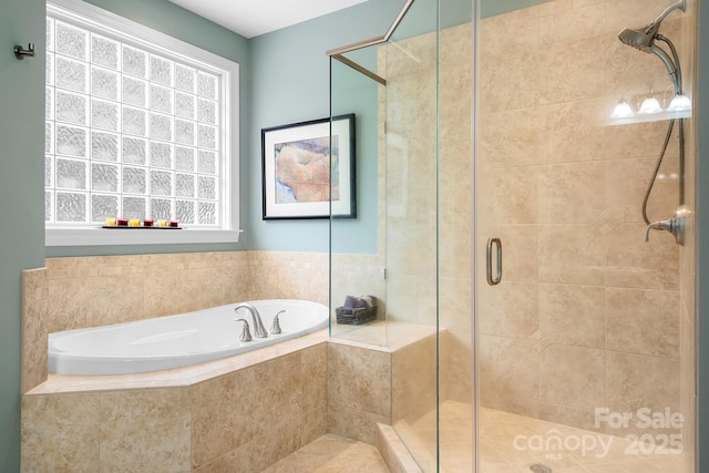 bathroom featuring plenty of natural light and shower with separate bathtub