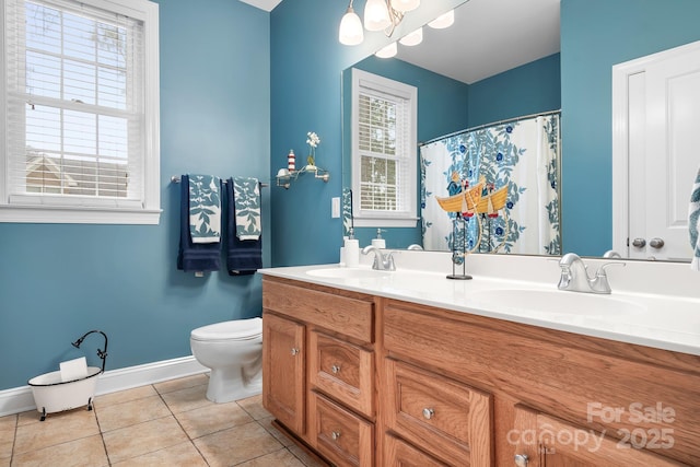 bathroom with vanity, plenty of natural light, tile patterned floors, and toilet