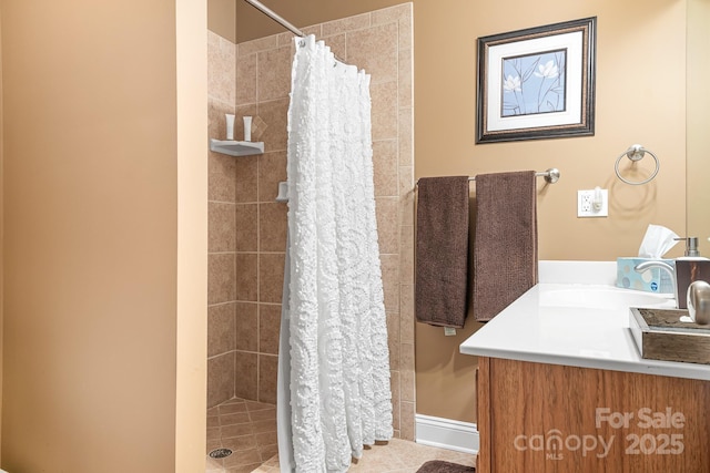 bathroom with tile patterned flooring, vanity, and walk in shower