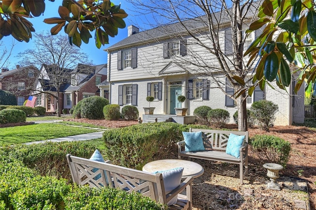 colonial inspired home featuring a front lawn