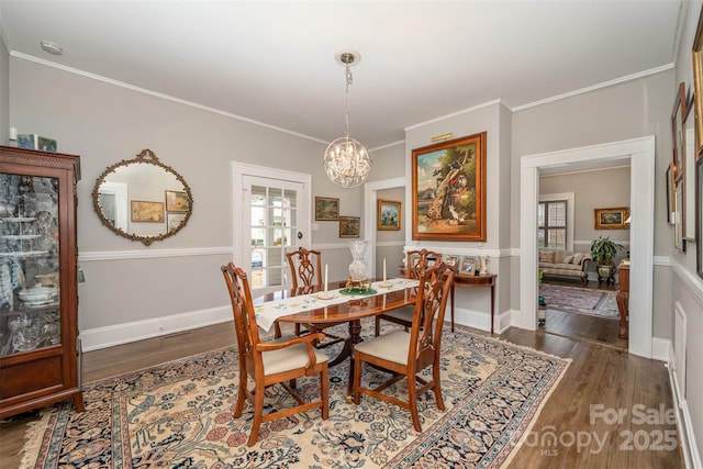 dining room with crown molding, a chandelier, and dark hardwood / wood-style flooring