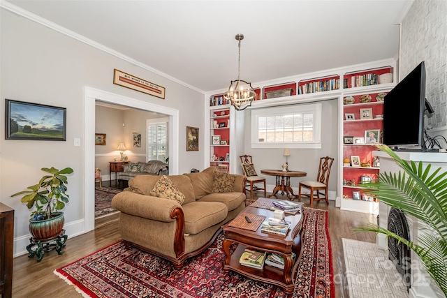 living room with ornamental molding, wood-type flooring, built in features, and a notable chandelier