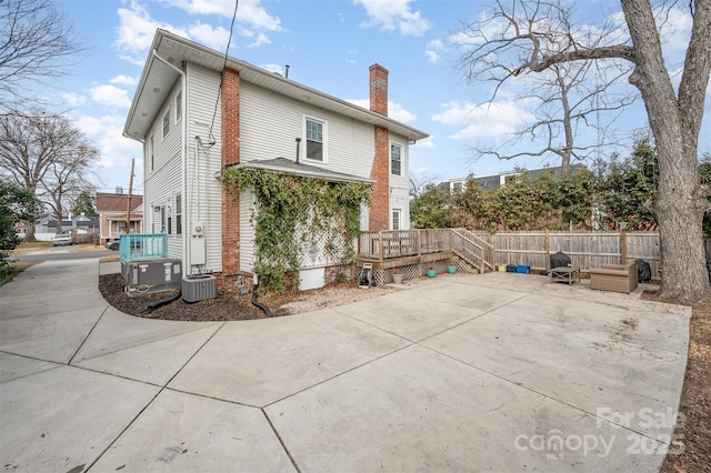 rear view of house with cooling unit, a patio, and a deck