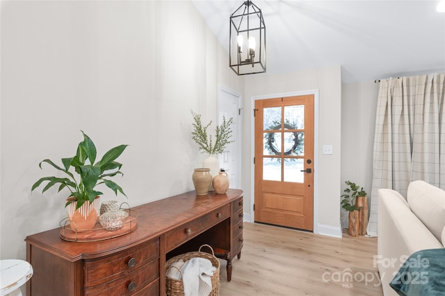 foyer with an inviting chandelier and light hardwood / wood-style flooring