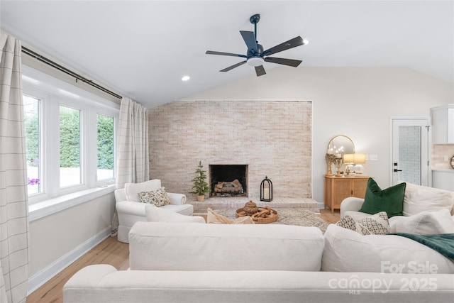 living room featuring ceiling fan, vaulted ceiling, and light wood-type flooring