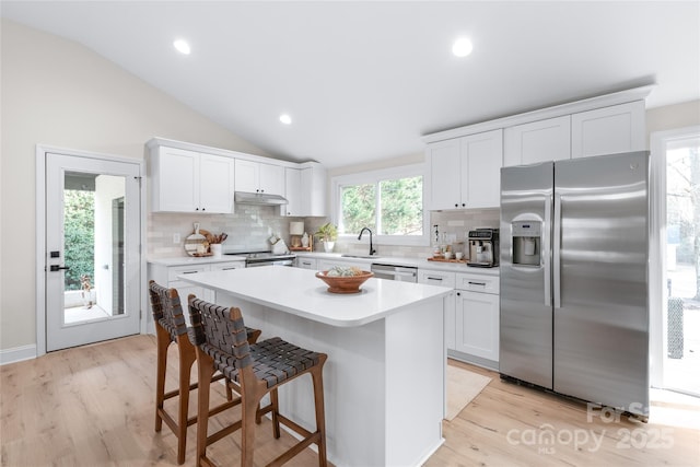 kitchen with white cabinetry, appliances with stainless steel finishes, sink, and a kitchen island