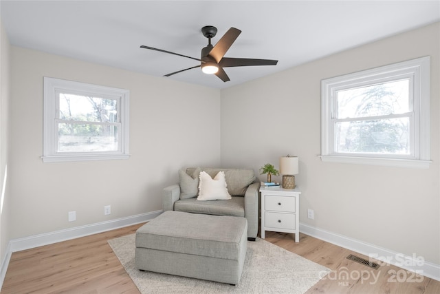 sitting room with ceiling fan, a healthy amount of sunlight, and light wood-type flooring