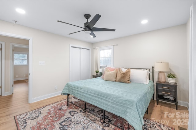 bedroom featuring ceiling fan, light hardwood / wood-style floors, and a closet