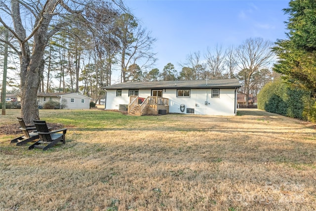 back of house with cooling unit and a yard