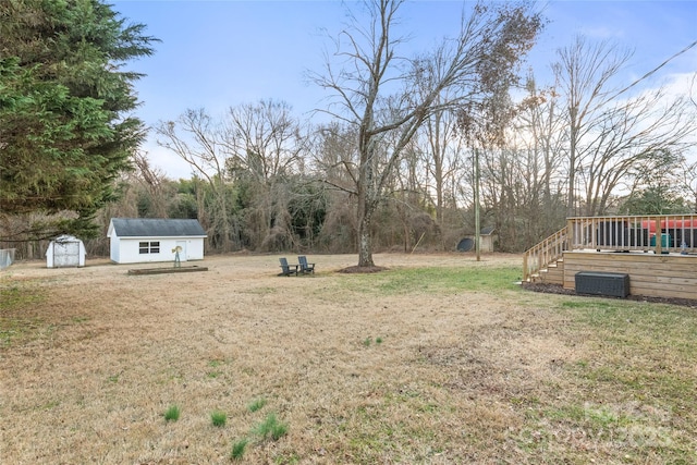 view of yard with a wooden deck and a storage unit