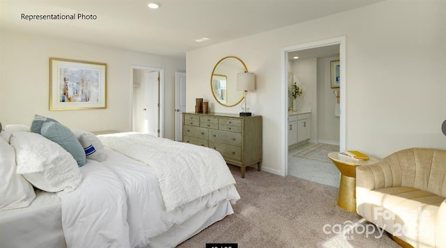 bedroom featuring ensuite bathroom and light colored carpet