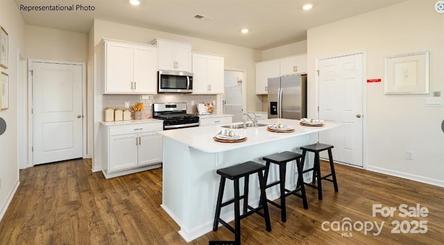 kitchen featuring white cabinetry, appliances with stainless steel finishes, sink, and a center island with sink