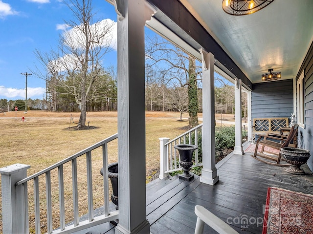 wooden deck with a porch and a yard