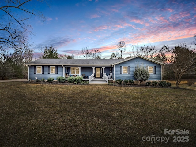 ranch-style house with a yard and covered porch