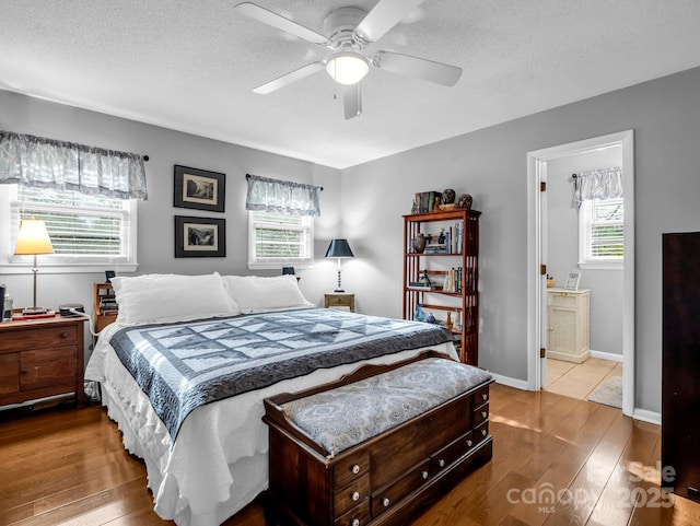 bedroom featuring multiple windows, hardwood / wood-style floors, and a textured ceiling