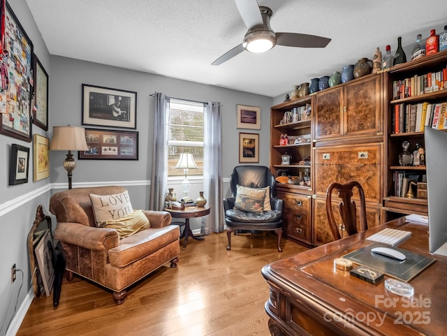 office area featuring ceiling fan, light hardwood / wood-style floors, and a textured ceiling