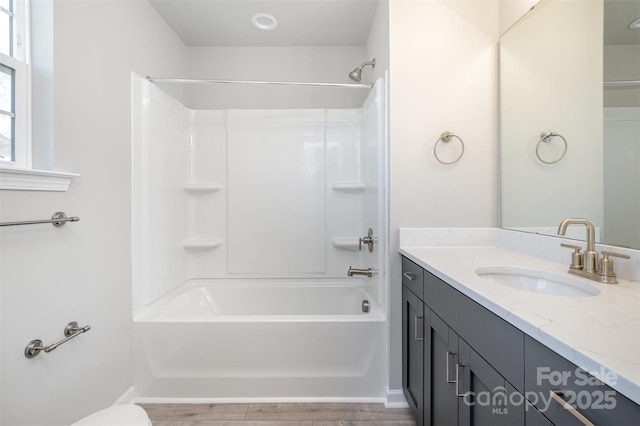 bathroom with vanity, hardwood / wood-style floors, and shower / bathtub combination