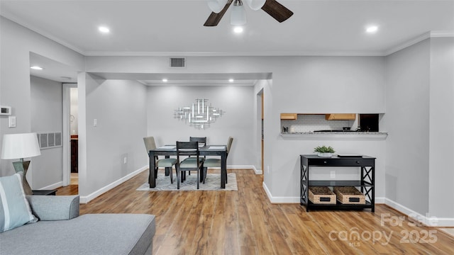 dining area featuring ceiling fan, crown molding, and hardwood / wood-style floors