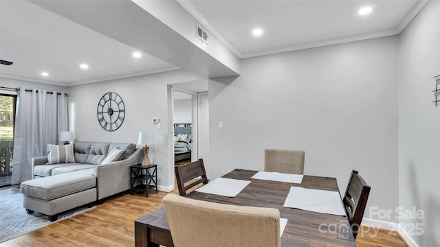 dining area with wood-type flooring and crown molding