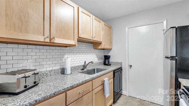 kitchen featuring sink, dishwasher, light brown cabinets, and stainless steel refrigerator