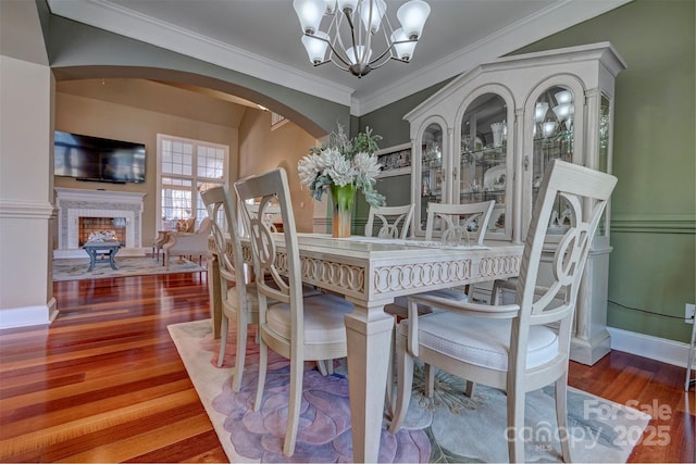 dining room with an inviting chandelier, ornamental molding, and hardwood / wood-style floors