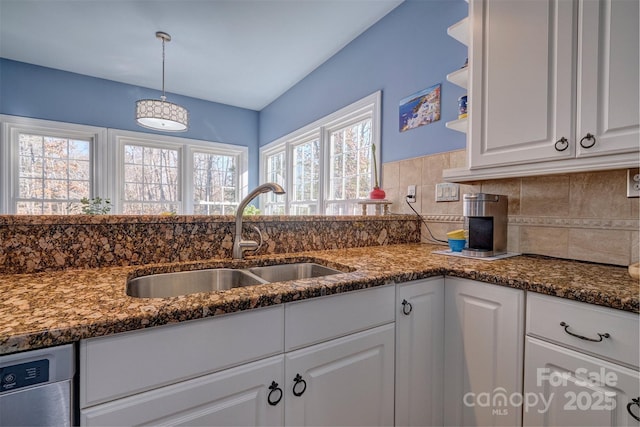 kitchen with white cabinetry, sink, decorative backsplash, hanging light fixtures, and stainless steel dishwasher