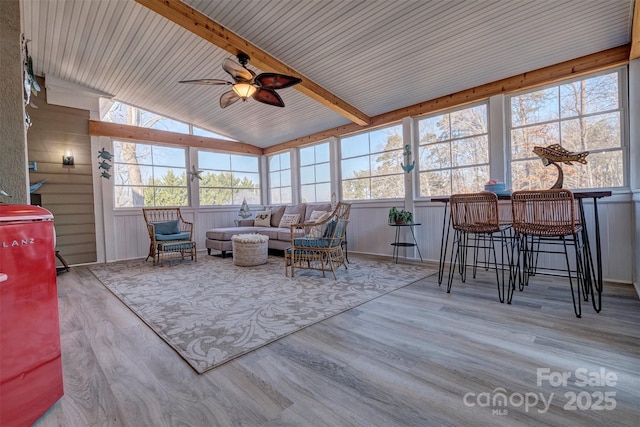 sunroom featuring vaulted ceiling with beams and ceiling fan