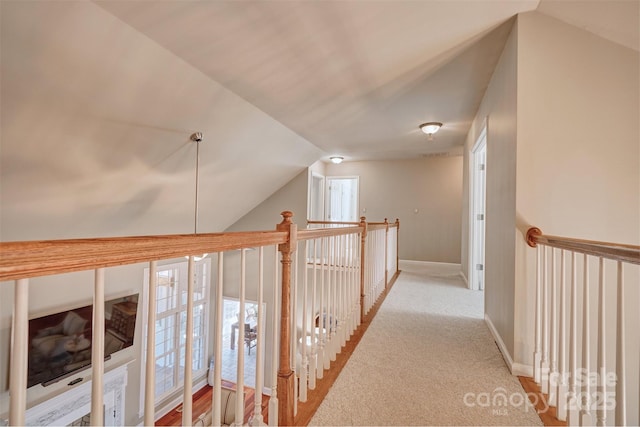 hallway featuring light colored carpet and lofted ceiling