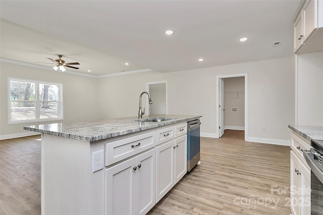 kitchen with sink, white cabinetry, a kitchen island with sink, light stone countertops, and stainless steel appliances