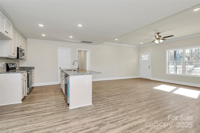 kitchen with light hardwood / wood-style floors, sink, light stone countertops, appliances with stainless steel finishes, and white cabinets