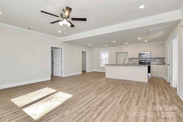 unfurnished living room featuring light wood-type flooring, ceiling fan, crown molding, and sink