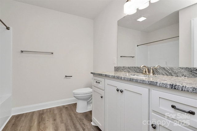 bathroom featuring toilet, vanity, and hardwood / wood-style floors