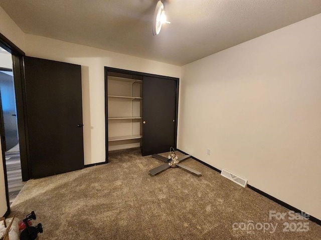 unfurnished bedroom featuring a closet and carpet flooring