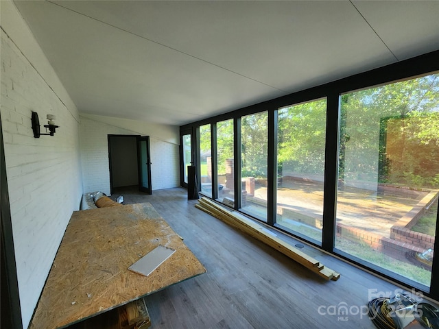 unfurnished sunroom featuring vaulted ceiling