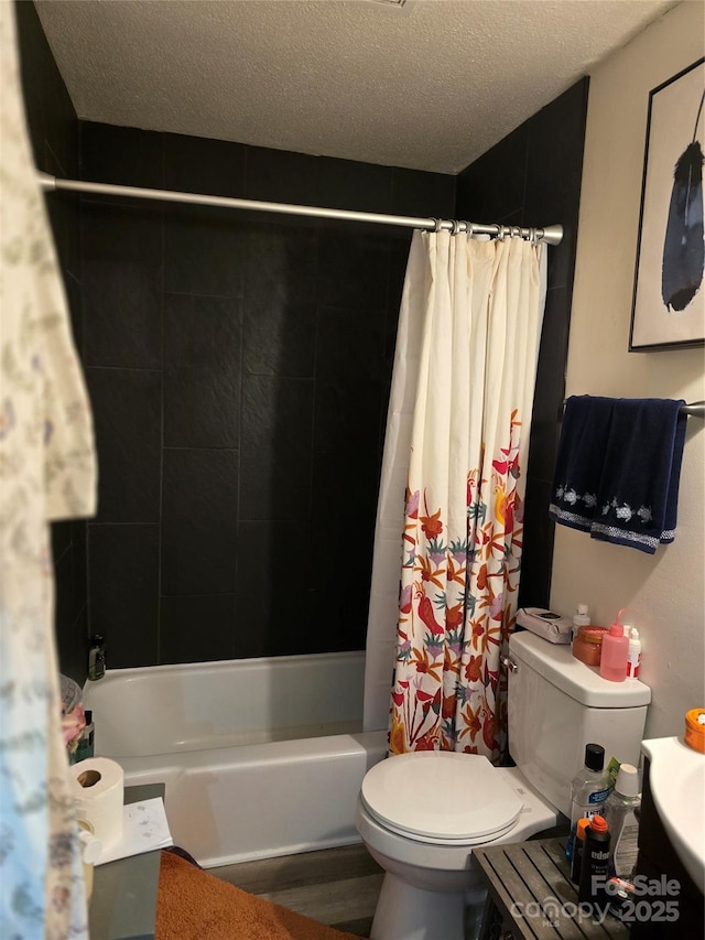 bathroom with shower / bath combo with shower curtain, toilet, and a textured ceiling