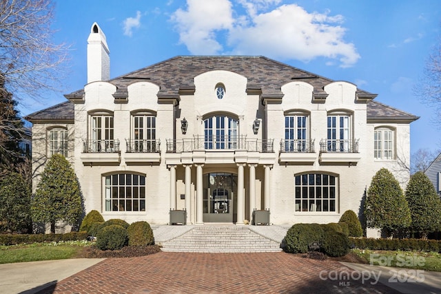 view of front of home with a balcony and french doors