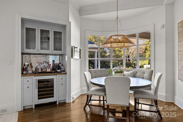 dining area featuring dark hardwood / wood-style flooring, indoor bar, and wine cooler