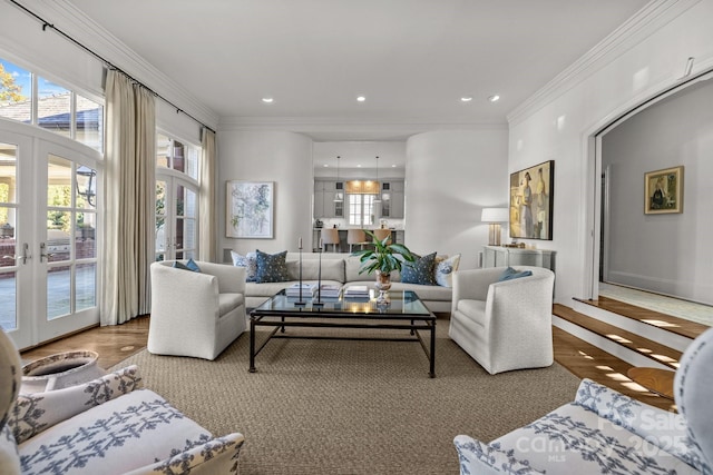 living room with hardwood / wood-style flooring, ornamental molding, and french doors