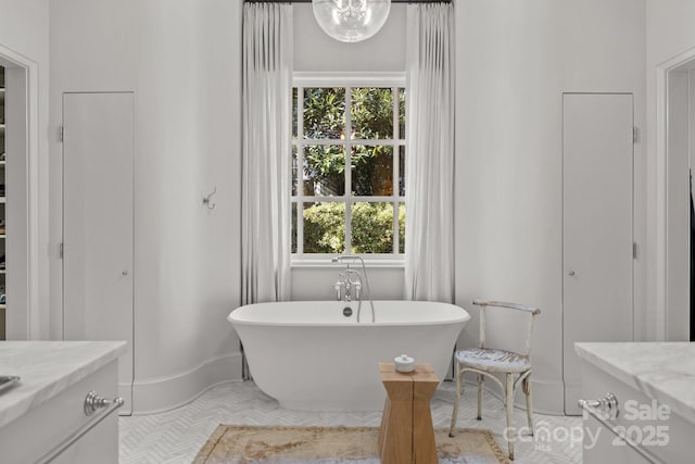 bathroom featuring a washtub, tile patterned flooring, a healthy amount of sunlight, and vanity