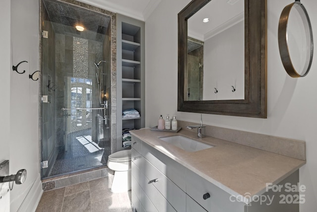 bathroom featuring vanity, toilet, built in features, walk in shower, and ornamental molding