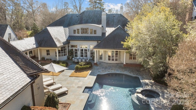 back of property with an outdoor fire pit and a patio